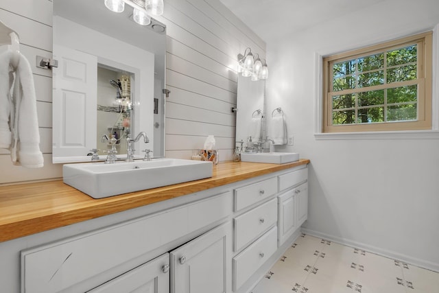 2227 Ten Oaks Dr, Tallahassee, FL 32312 - bathroom with baseboards, double vanity, a sink, and wood walls
