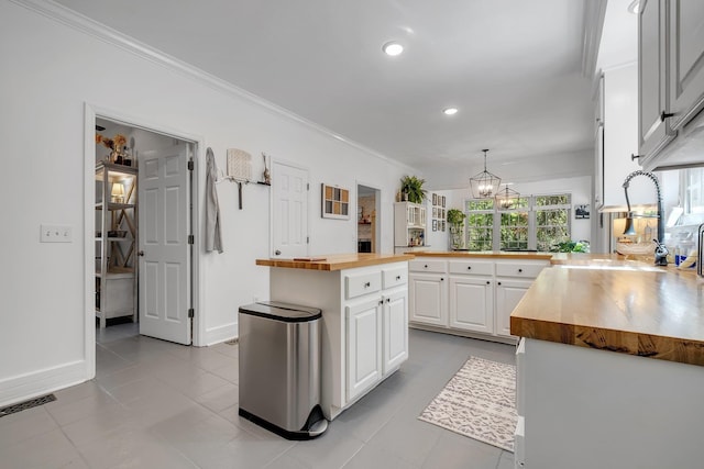 2227 Ten Oaks Dr, Tallahassee, FL 32312 - kitchen with wood counters, white cabinetry, a chandelier, and ornamental molding