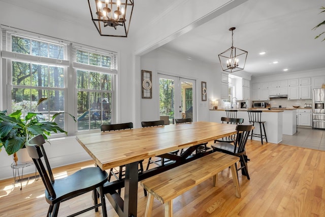 2227 Ten Oaks Dr, Tallahassee, FL 32312 - dining room with ornamental molding, an inviting chandelier, light wood-style floors, and french doors