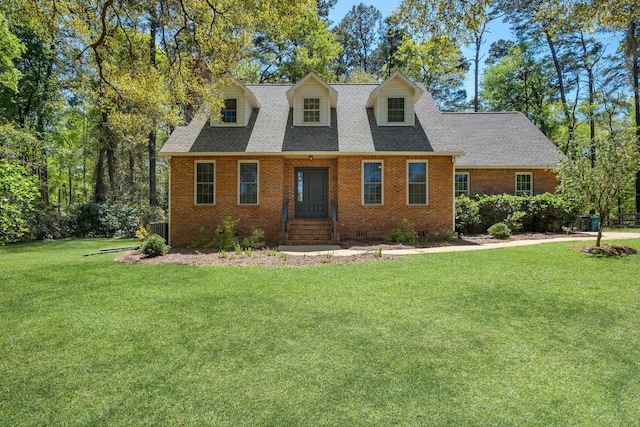 2227 Ten Oaks Dr, Tallahassee, FL 32312 - cape cod house featuring central air condition unit, a front yard, brick siding, and roof with shingles