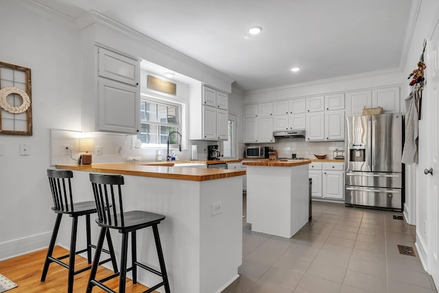 2227 Ten Oaks Dr, Tallahassee, FL 32312 - kitchen with butcher block countertops, backsplash, a sink, a peninsula, and appliances with stainless steel finishes
