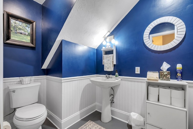 2227 Ten Oaks Dr, Tallahassee, FL 32312 - half bath featuring lofted ceiling, a textured ceiling, toilet, and wainscoting