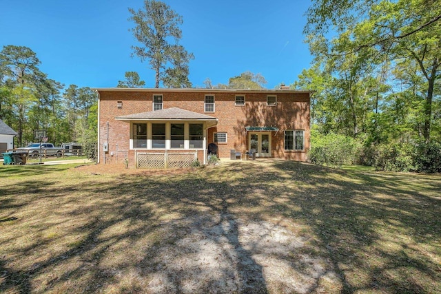 2227 Ten Oaks Dr, Tallahassee, FL 32312 - back of house featuring a lawn, a sunroom, french doors, and brick siding