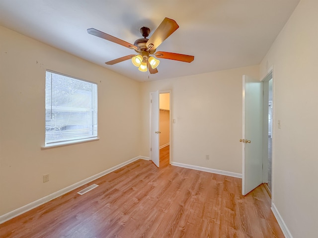 unfurnished bedroom featuring light wood-style flooring, baseboards, ceiling fan, and visible vents