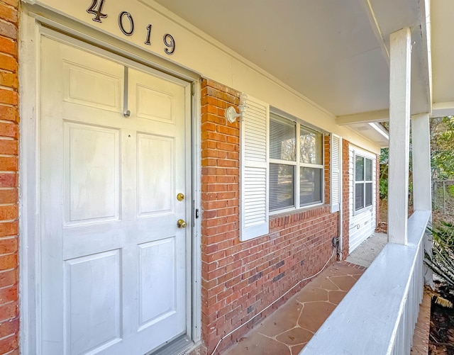 property entrance featuring brick siding