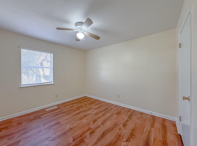 empty room with a ceiling fan, baseboards, light wood finished floors, and visible vents