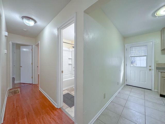 hallway featuring baseboards and light tile patterned floors