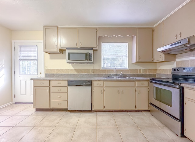 kitchen featuring a sink, cream cabinetry, stainless steel appliances, and under cabinet range hood