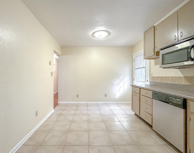 kitchen featuring light countertops, baseboards, stainless steel appliances, and light tile patterned floors