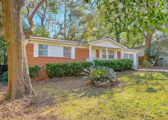 single story home featuring brick siding, a front lawn, and a porch