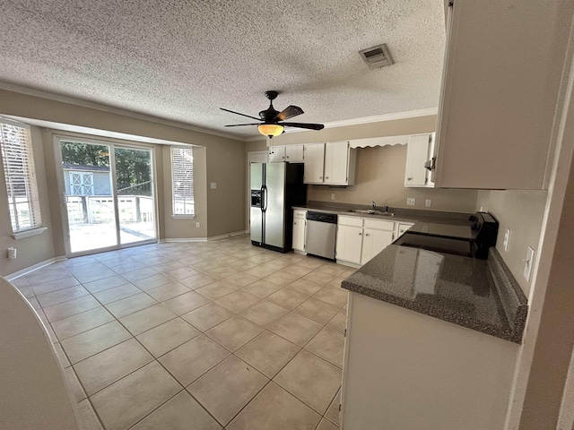 6842 Tomy Lee Trl, Tallahassee, FL 32309 - kitchen with stainless steel appliances, a sink, crown molding, light tile patterned floors, and white cabinets