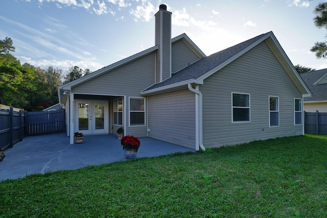 back of property featuring a patio area and a lawn