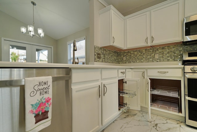 kitchen featuring backsplash, a healthy amount of sunlight, white cabinets, and stainless steel appliances