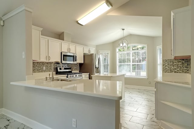 kitchen featuring stainless steel appliances, kitchen peninsula, a chandelier, lofted ceiling, and white cabinets