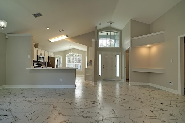 foyer with an inviting chandelier and vaulted ceiling