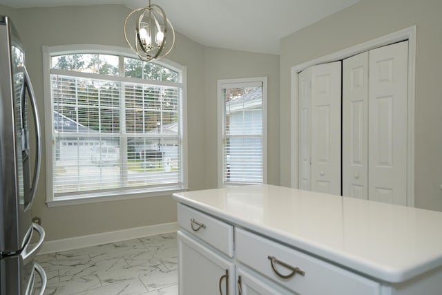 kitchen with white cabinets, stainless steel refrigerator, and plenty of natural light