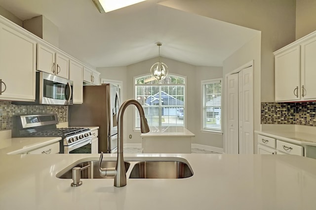 kitchen featuring sink, an inviting chandelier, pendant lighting, white cabinets, and appliances with stainless steel finishes