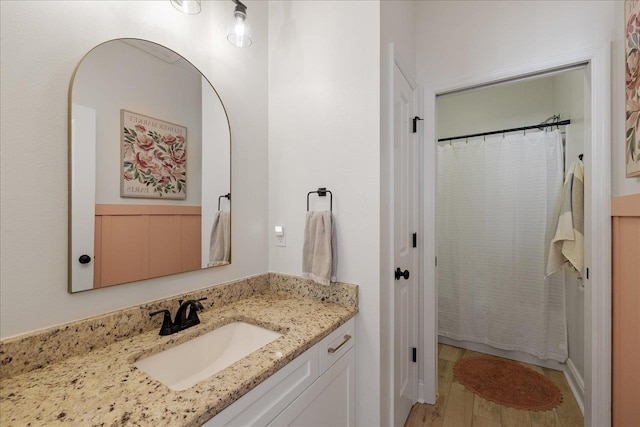 full bath featuring a shower with curtain, wood finished floors, and vanity