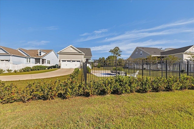 view of yard featuring a residential view, driveway, and fence
