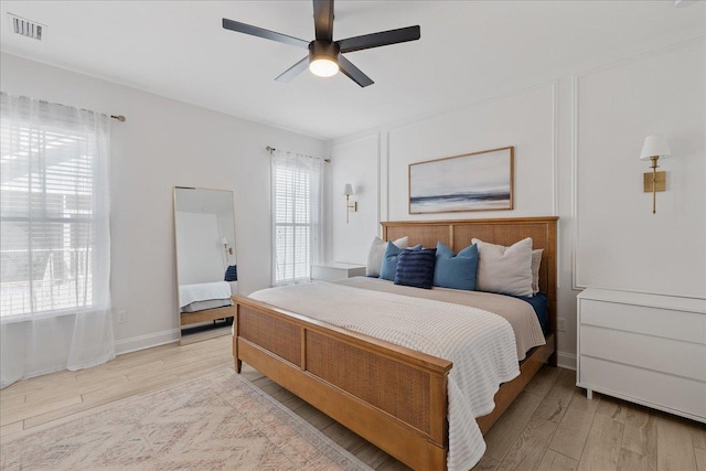 bedroom with visible vents, multiple windows, and light wood finished floors