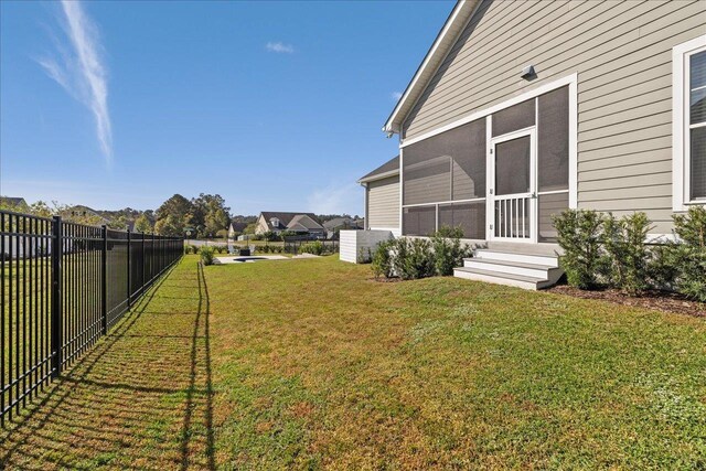 view of yard featuring fence and a sunroom