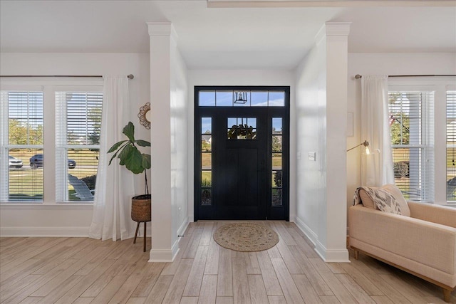 entryway with light wood-style flooring, plenty of natural light, and baseboards