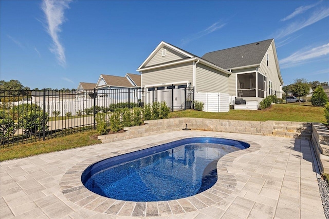 view of swimming pool featuring a patio, fence, a fenced in pool, a yard, and a sunroom