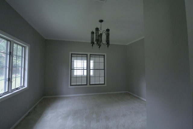 carpeted empty room with ornamental molding and an inviting chandelier