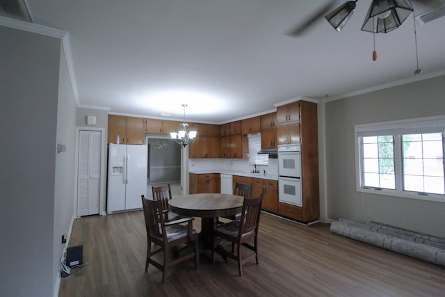 dining room with crown molding, sink, and dark hardwood / wood-style flooring