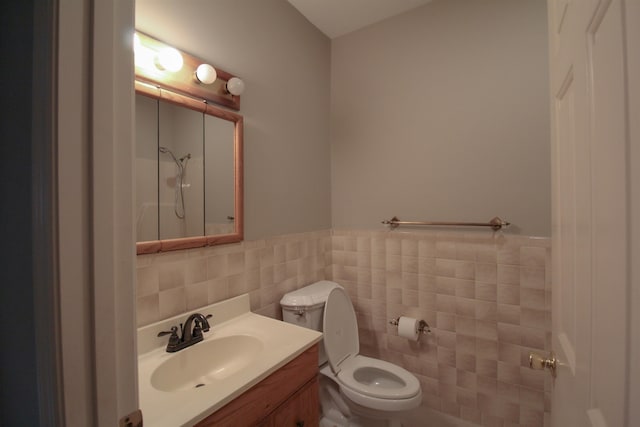 bathroom featuring tile walls, vanity, and toilet