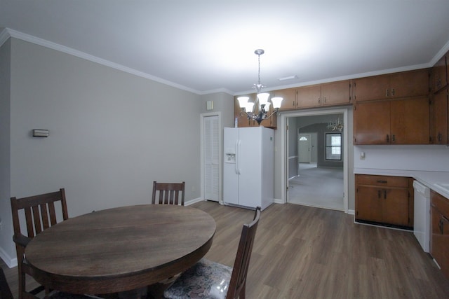 dining room with light hardwood / wood-style floors, a chandelier, and crown molding