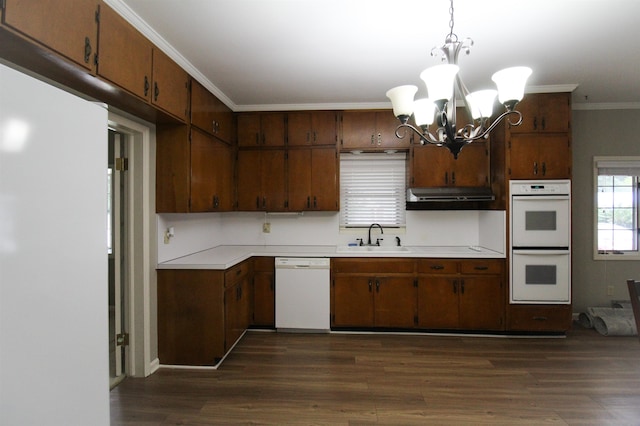 kitchen with hanging light fixtures, a chandelier, sink, dark hardwood / wood-style floors, and white appliances