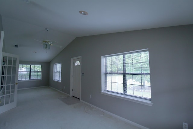 foyer with ceiling fan, vaulted ceiling, and light colored carpet