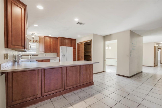 kitchen featuring white appliances, kitchen peninsula, and light tile patterned floors