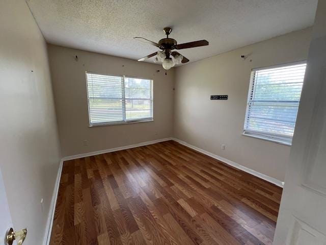 spare room featuring dark wood-type flooring, a textured ceiling, and ceiling fan