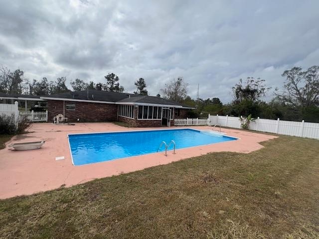 view of pool featuring a lawn and a patio