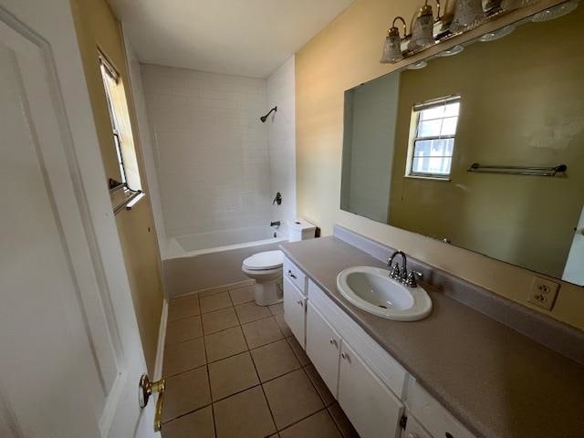 full bathroom featuring tile patterned flooring, vanity, tiled shower / bath combo, and toilet