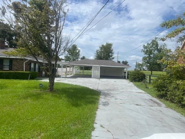 view of front of property with a front lawn and a carport