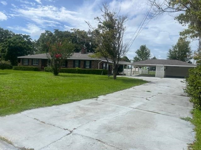 single story home featuring a carport and a front lawn