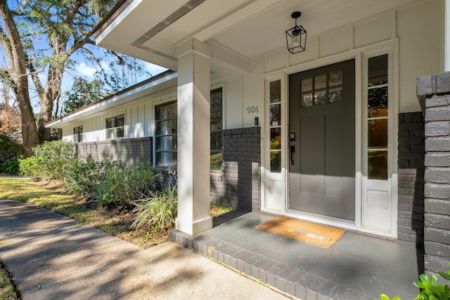 view of exterior entry featuring covered porch