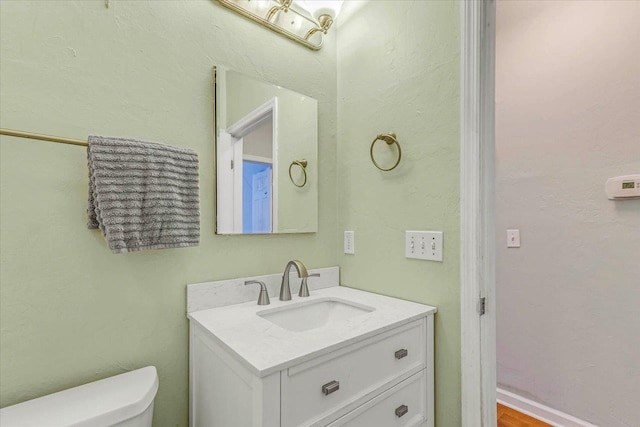 half bathroom featuring toilet and vanity