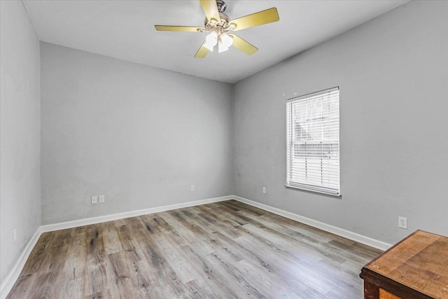 unfurnished room featuring baseboards, wood finished floors, and a ceiling fan
