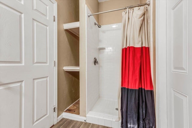 bathroom featuring a shower stall and wood finished floors