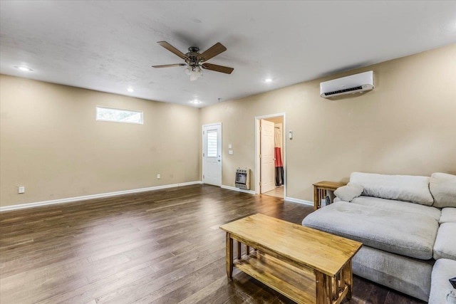 living room featuring ceiling fan, dark wood-style floors, baseboards, heating unit, and a wall mounted air conditioner