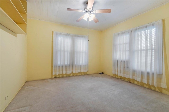 carpeted spare room with ceiling fan