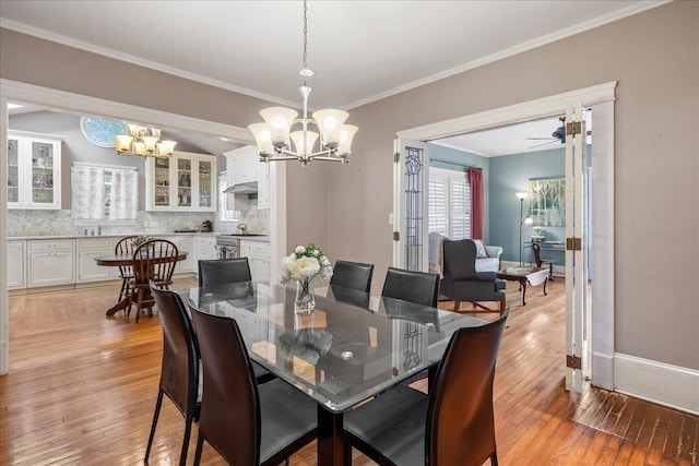 dining room featuring crown molding, sink, ceiling fan with notable chandelier, and light wood-type flooring