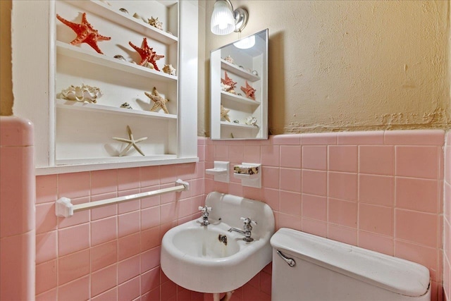 bathroom with built in shelves, toilet, and sink