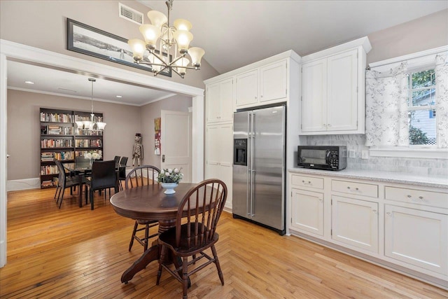 dining room featuring ornamental molding, a chandelier, and light hardwood / wood-style flooring