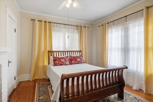 bedroom with crown molding, ceiling fan, and wood-type flooring