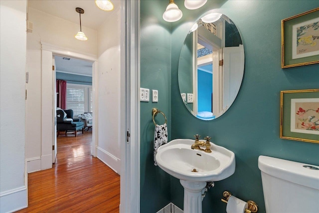 bathroom featuring wood-type flooring and toilet